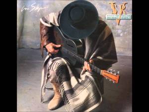 SRV's classic look: guitar in the hands, stetson on the head, cowboy boots on, and a poncho for good measure.